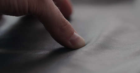 closeup man hand checking soft gray leather clothesの写真素材