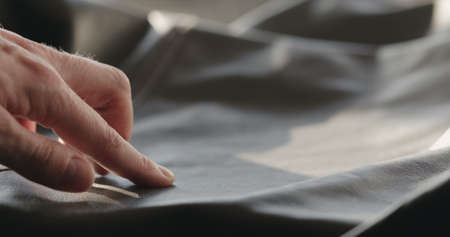man hand checking soft gray leather clothesの写真素材