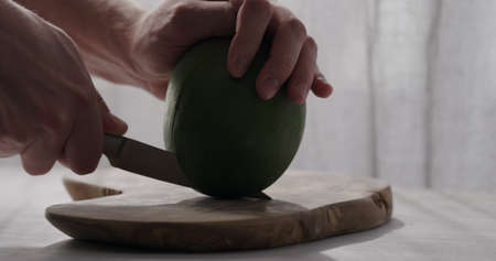 man cut green mango on olive wood boardの写真素材