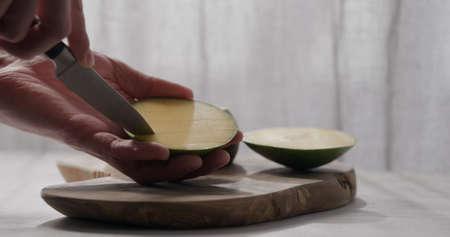 man cut green mango on olive wood boardの写真素材