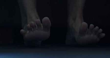 man put his feet on floor early morning and massage themの写真素材