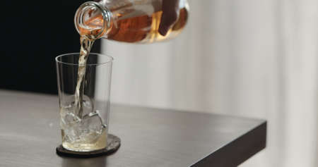 closeup pour mate drink in a tumbler glass on walnut table with copy spaceの写真素材