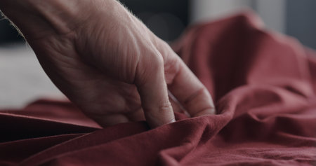 man touching red cotton clothes closeupの写真素材