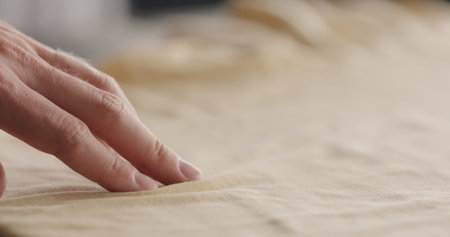 man touching yellow cotton clothes closeupの写真素材