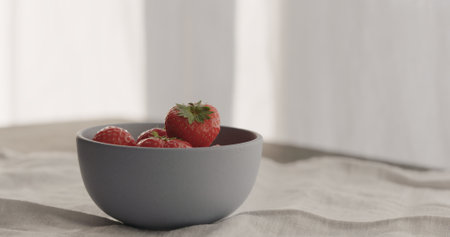 fresh strawberries from blue bowl on linen clothの写真素材