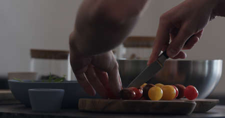 man making salad cut tomatoesの写真素材