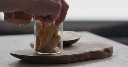 man pack freeze dried mango in glass jar on olive wood boardの写真素材