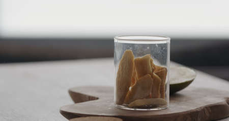 freeze dried mango in glass jar on olive wood boardの写真素材