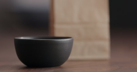 Black empty ceramic bowl on walnut tableの写真素材