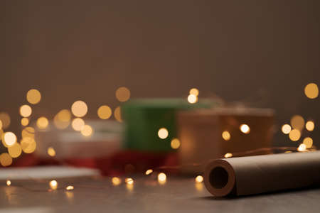 Gift boxes and festive packaging with christmas light on a table closeup