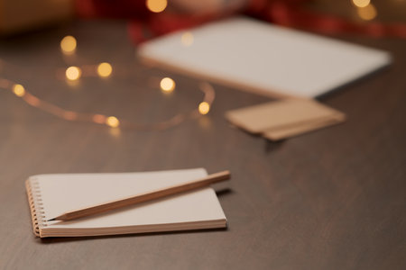 White paper notepad with pencil on wood table with christmas decorationsの写真素材