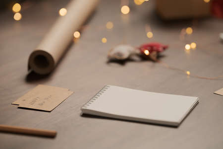 White paper notepad with pencil on wood table with christmas decorationsの写真素材