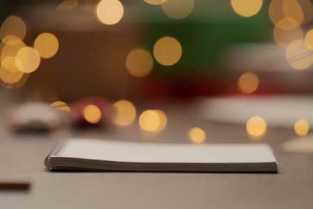 White paper notepad with pencil on wood table with christmas decorationsの写真素材