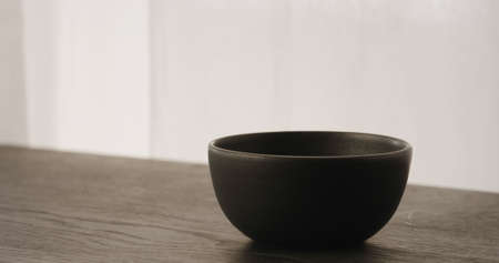 Black empty ceramic bowl on black wood tableの写真素材