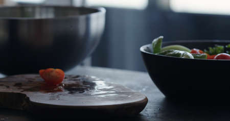 man making salad in black bowl closeupの写真素材