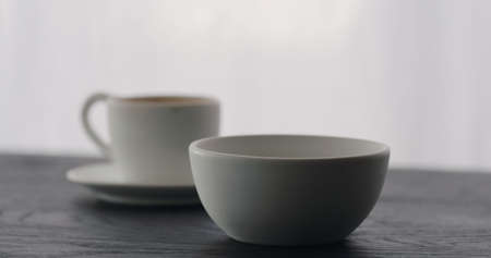 white bowl with espresso cup on black wood tableの写真素材