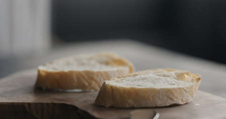 slices of rustic ciabatta on olive wood boardの写真素材