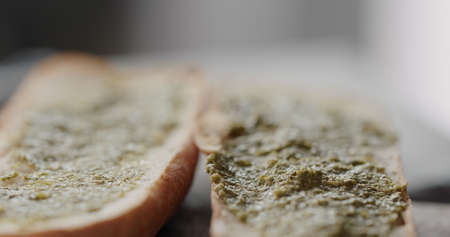 pesto on baguette halves, making sandwichの写真素材