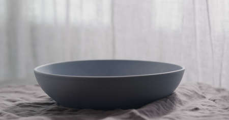 Empty blue bowl on linen napkinの写真素材