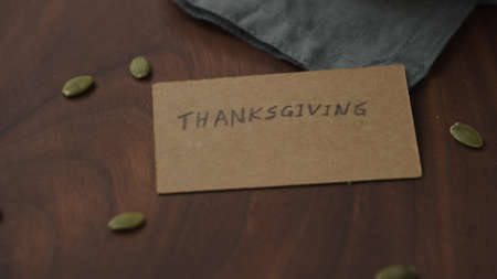 thanksgving card on walnut table with pumpkin seedsの写真素材