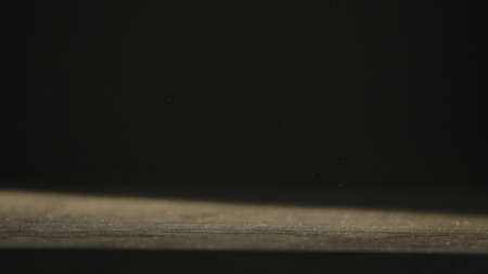 dust fall on wood table backlit by sunの写真素材
