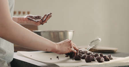 young woman making chocolate truffles on home kictchenの写真素材