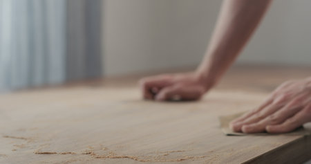 man hand sanding black walnut wood tableの写真素材