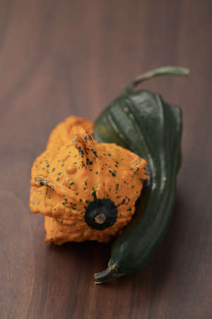 small decorative funny shaped pumkin on wood tableの写真素材