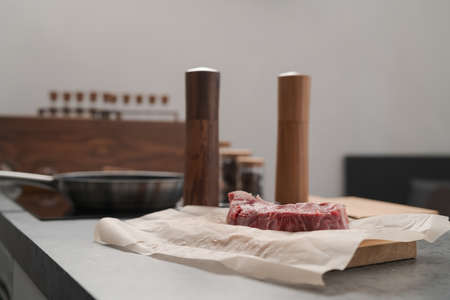 Raw new york sirloin steak on parchment paper warming up before cooking