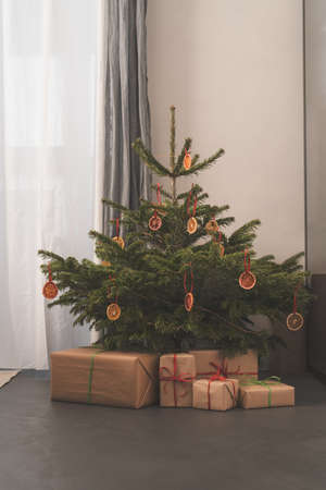 Small christmas tree with natural decorations and gift boxesの写真素材