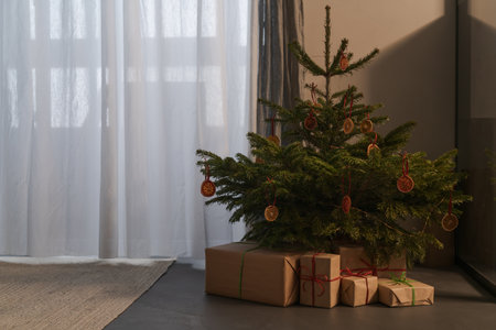 Small christmas tree with natural decorations and gift boxesの写真素材