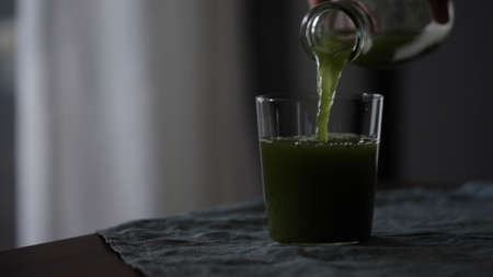 pour matcha drink in tumbler glass on tableの写真素材