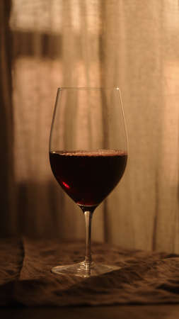 red wine in wineglass with sunset light