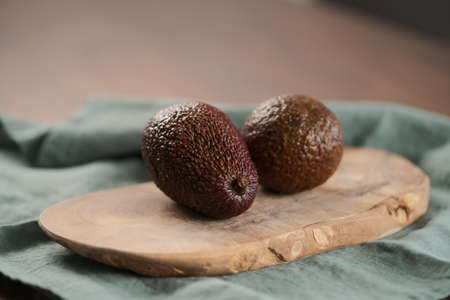Two avocados on olive wood board