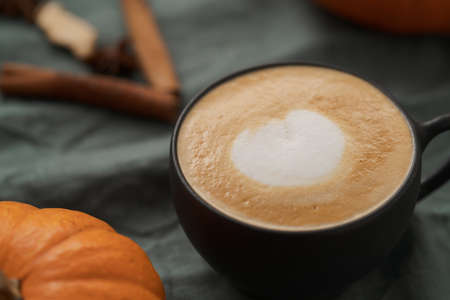 Pumpkin spicy latte in black cup on linne clothの写真素材