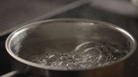 closeup water boiling in saucepan on induction stoveの写真素材