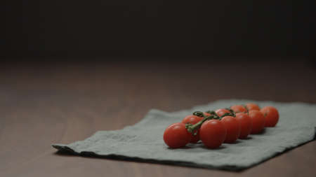 cherry tomatoes on a branch on linen clothの写真素材