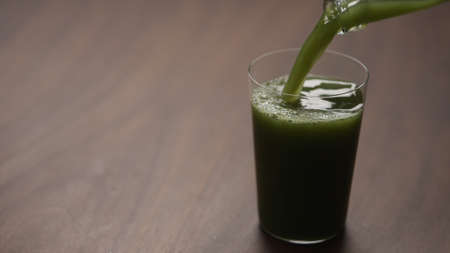 pour matcha drink in tumbler glass on tableの写真素材