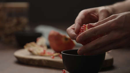 man peeling pomegranate close upの写真素材
