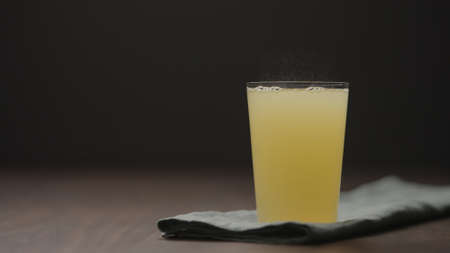 lemonade in tumbler glass from wood table with copy space