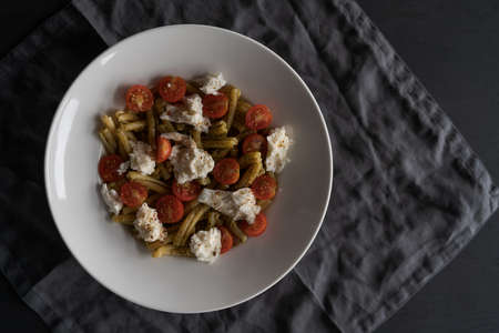 casarecce pasta with pesto, fresh cherry tomatoes and mozzarella