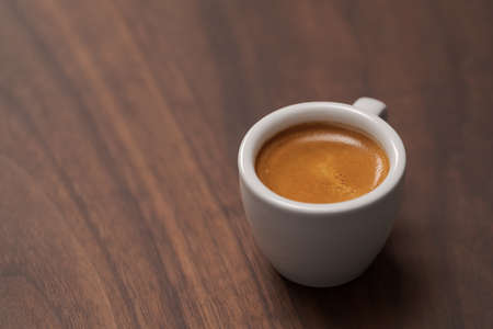 Cup of fresh espresso in white cup on walnut table with copy spaceの写真素材
