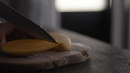 man cut fresh yellow mango on wood boardの写真素材