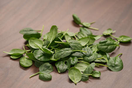 Fresh spinach leaves on walnut wood tableの写真素材