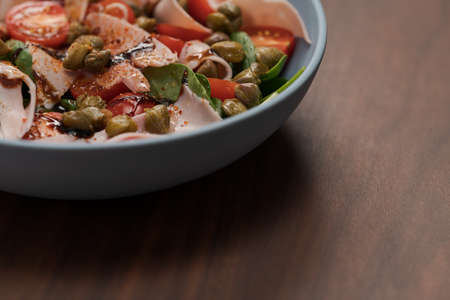 Salad with prosciutto cotto, cherry tomatoes and spinach in blue bowlの写真素材