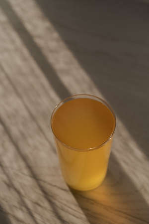 Ginger beer in tumbler glass on white oak table wuth sunlightの写真素材