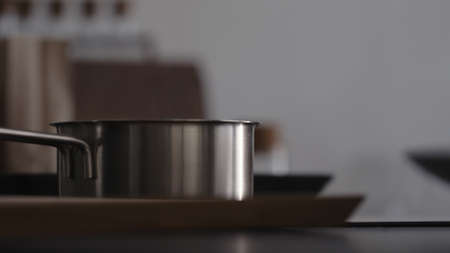 Steam rising from saucepan with boiling water on kitchen