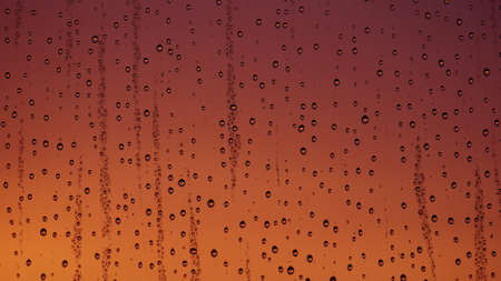 Water drops on window glass with sunset lightの写真素材