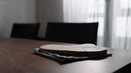Empty olive wood board on walnut tableの写真素材