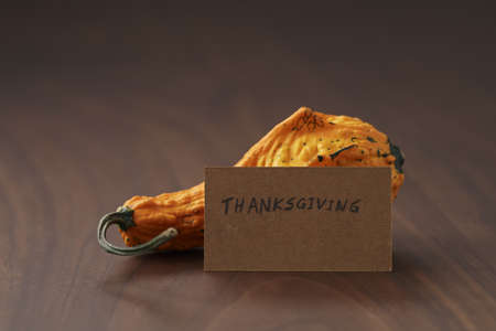 Decorative pear pumpkin on wood table with thanksgiving card